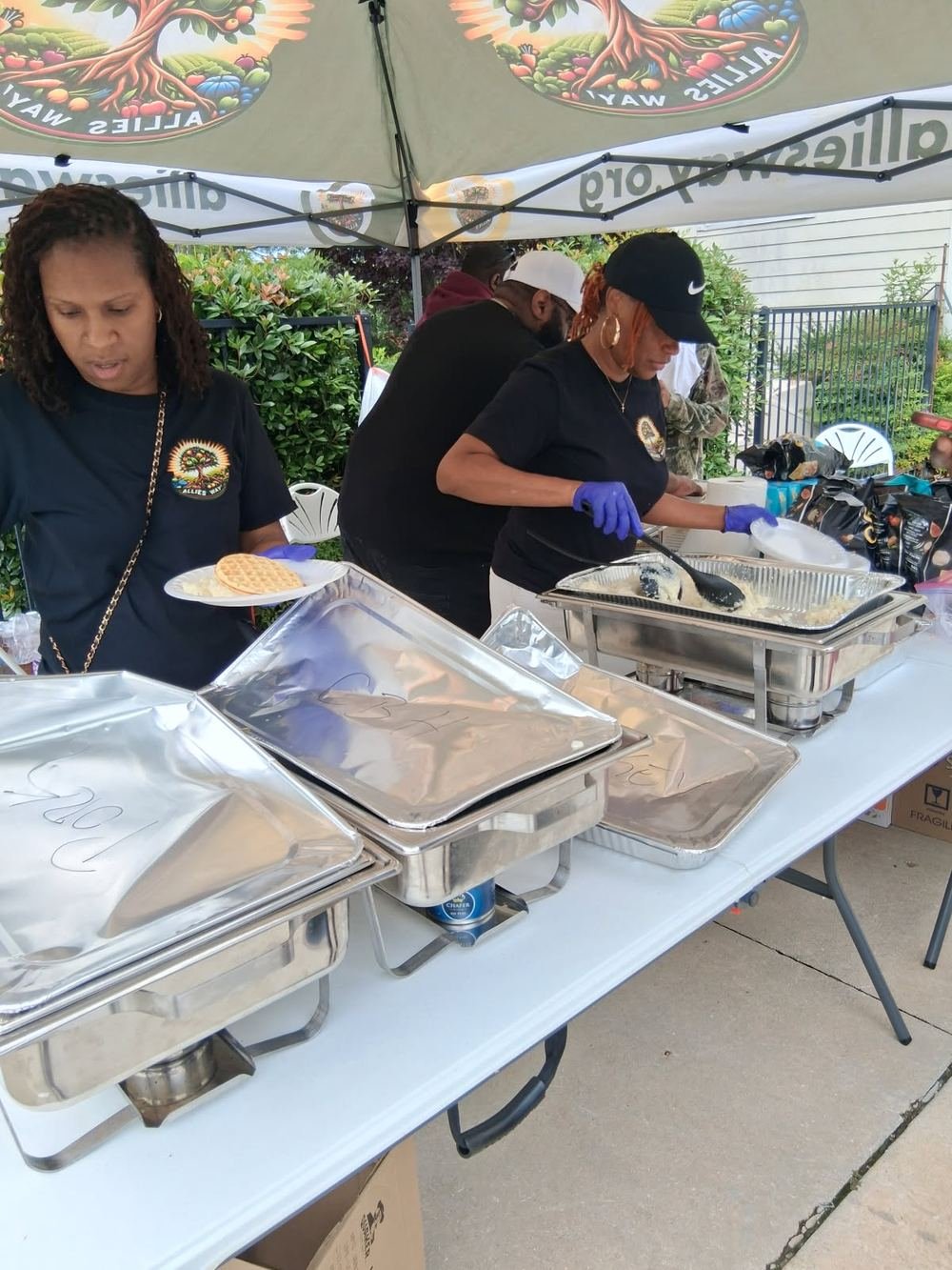 Volunteers serving hot food from chafing dishes