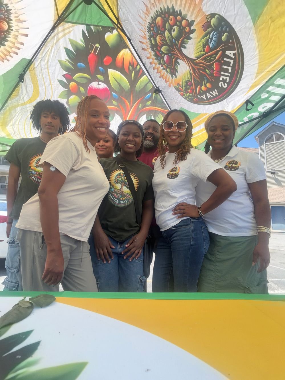 Allies Way volunteers smiling under the Allies Way tent